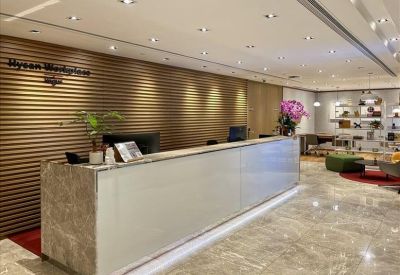 Sleek reception desk with marble finish and a slatted wood feature wall.