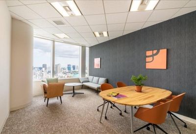 Private office suite with a circular meeting table, grey accent wall, and panoramic window views.