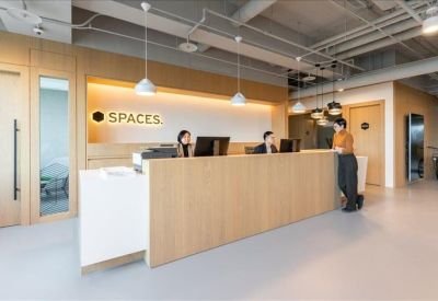 Bright reception area with a long wooden desk and minimalist hanging lights.