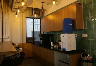 Communal kitchen area with counter, coffee machines, and appliances.