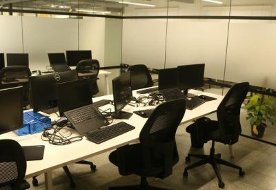 Office space with multiple desks and chairs in an open-plan layout.