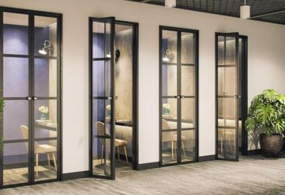 Individual glass-fronted phone booths or focus rooms with internal seating and lighting.