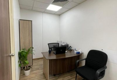 Private office featuring a curved wood desk, wood flooring, and a potted plant.