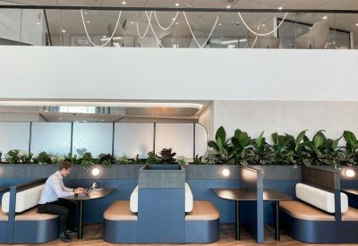 Comfortable blue booth seating area for informal meetings with views of indoor greenery.