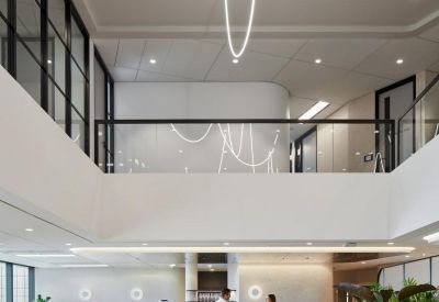Spacious two-story cafe and breakout area with a central coffee bar and wooden floors.