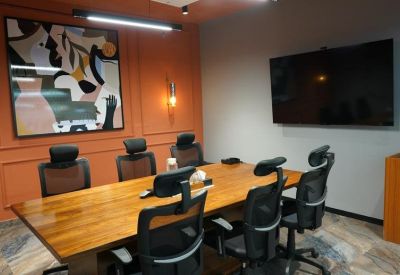 Professional meeting room with a large wooden table, executive chairs, and abstract wall art.