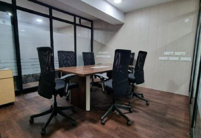 Professional meeting room with a dark wood table and black mesh chairs on hardwood flooring.