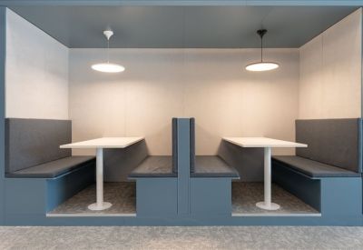 Private semi-enclosed meeting booths with cushioned seating and individual pendant lighting.