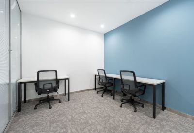 Three-person private office with white desks and a vibrant blue accent wall.