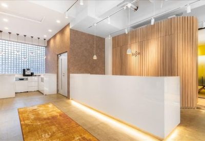 Bright reception area with white desk, wooden accent wall, and hanging pendant lights.