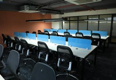 Long rows of white workstations with black mesh chairs and blue partitions.