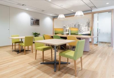 Communal dining area with lime green chairs and city-themed wall art.