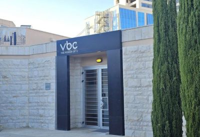 Modern stone entrance with dark metal framing and vbc branding.