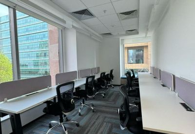 Modern open-plan workspace with multiple desks and city views.