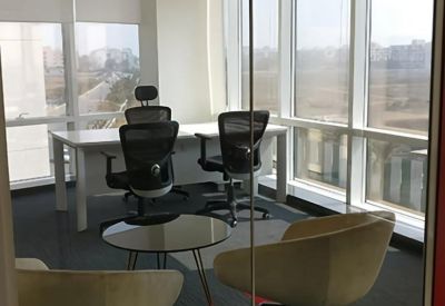 Sunlit private office suite featuring a large desk, ergonomic chairs, and city views.