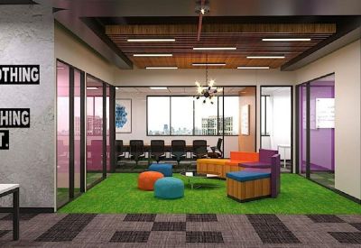 Bright breakout space with green artificial grass flooring and colourful ottoman seating.