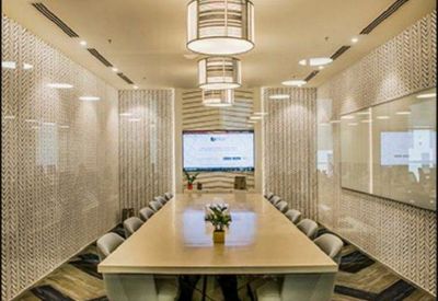 Modern boardroom featuring a long wooden table and decorative textured walls.
