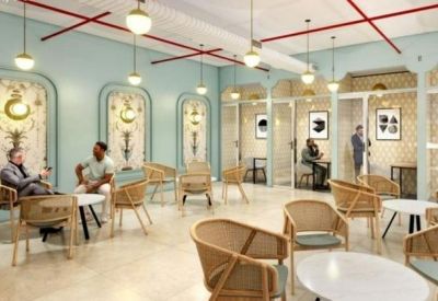 Spacious lounge with woven chairs, pale blue walls, and patterned alcoves.