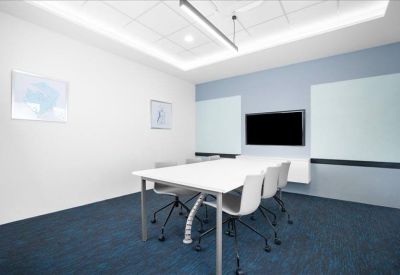Minimalist meeting room with white table, grey chairs, and a wall-mounted screen.
