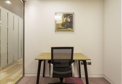 Private office with a light wood desk, ergonomic chair, and modern wall art.
