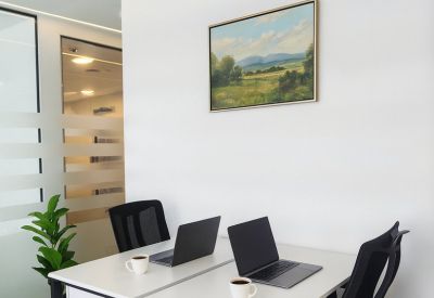Dual workstation setup with a landscape painting and modern linear pendant lighting.