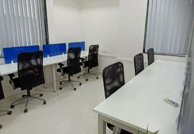Shared workspace with white desks and blue privacy dividers.