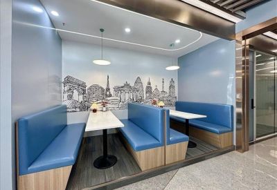 Cozy semi-private booths with blue seating and a skyline mural backdrop.
