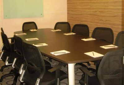 Meeting room featuring a dark wood conference table and black mesh ergonomic chairs.