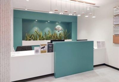 Professional reception area with a teal and white desk and integrated plant display.