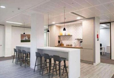 Contemporary office breakout area with high-top breakfast bar seating and kitchenette.
