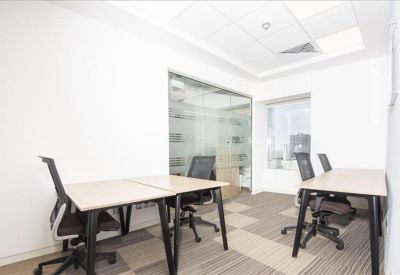 Bright private office suite with two desks and glass partitions.
