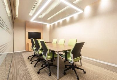 Contemporary meeting room with light green chairs and a rectangular halo light fixture.