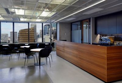 Modern break area with a long wooden counter and cafe-style seating overlooking the city.