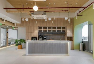 Modern office kitchen and pantry area with wooden cabinetry and a sleek grey service counter.