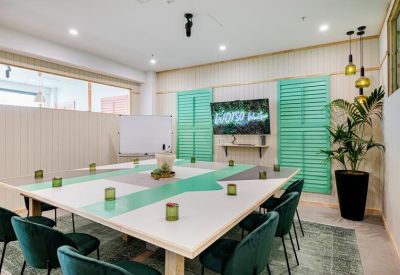Meeting room with green shutters and equipped with a TV.