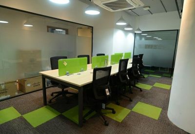 Small meeting room with lime green desk dividers and checkered floor tiles.