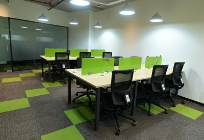 Multiple desk banks with lime green privacy screens under modern pendant lighting.