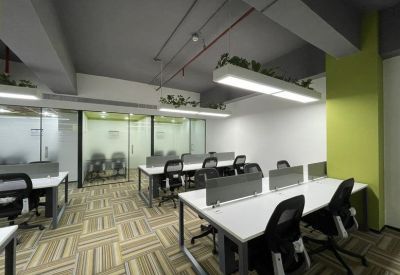 Bright workspace featuring white desks, grey dividers, and a lime green accent column.