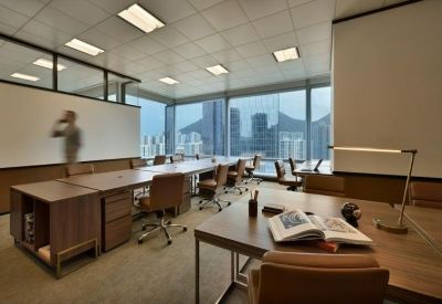 Professional open-plan office with wooden desks and a view of the city skyline.