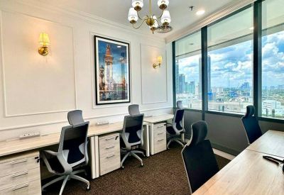 Bright multi-person office with white desks and floor-to-ceiling windows.