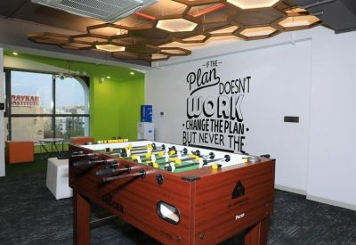 Spacious lounge with a foosball table and motivational wall graphic.