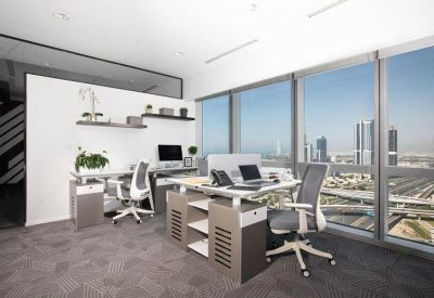 Open-plan office space featuring desks and ergonomic chairs with views of the city skyline.