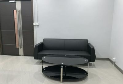 Lounge area featuring a black leather sofa and a sleek glass coffee table.