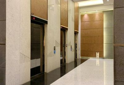 Polished building lobby with marble walls and elevator entrances.