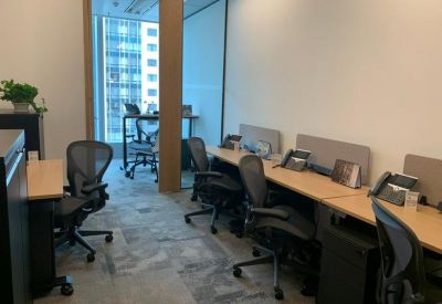 Bright office suite with ergonomic chairs and wooden desks near a window.