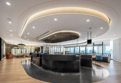 Modern curved reception desk with integrated warm lighting and wood flooring.