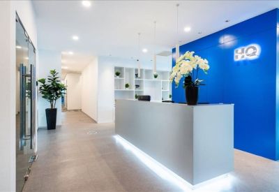 Sleek reception desk with integrated lighting and a bold blue feature wall.