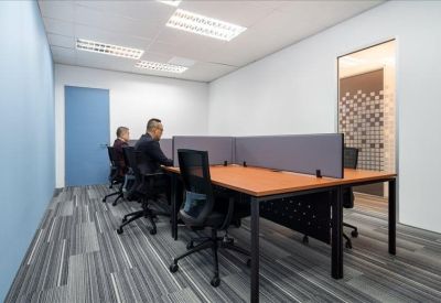 Bright office space with private workstations and a patterned glass door.