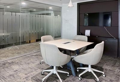 Contemporary breakroom with green seating, a long dining table, and a refreshment station.