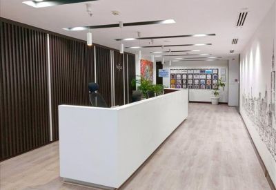 Modern white reception desk in a bright lobby with wood-slat wall detailing.